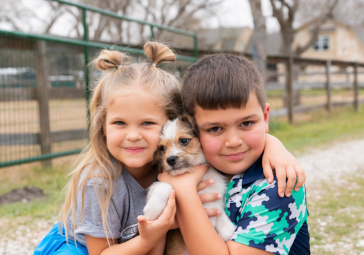 two kids holding a puppy at the new property