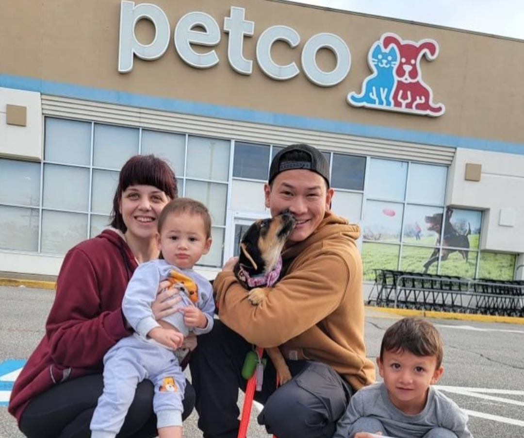 Family of four with a dog in front of a Petco store
